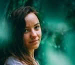 Captivating portrait of a woman surrounded by lush greenery, exuding tranquility.